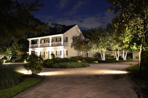Driveway and house lit up with properly placed outdoor lighting