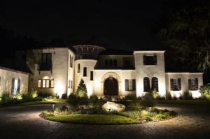 Mansion and driveway lit up at night